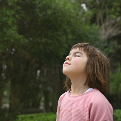 A young girl breathes fresh air outdoors.