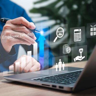 An employee navigating through their workplace's benefits compensation strategies from a laptop.