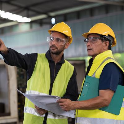 Engineers discussing on work maintenance issues in their industry factory.