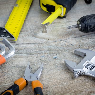 Assorted construction hand tools scattered on a work surface.