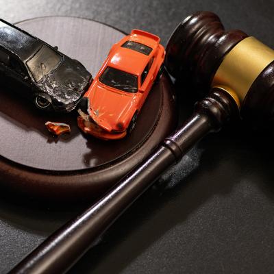 Figures of crashed cars and a gavel as a concept of traffic court civil litigation.