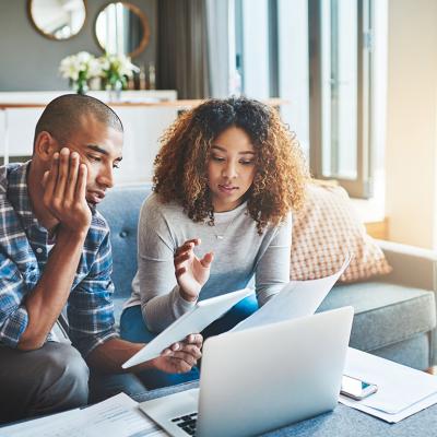 A young couple calculating expenses at home.