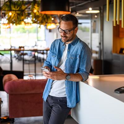 A businessman checking social media from his smartphone for their business' marketing.