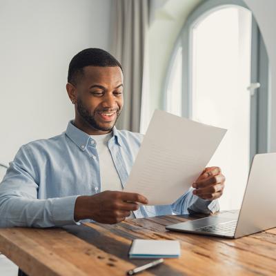 A young adult reading an important letter of his personal achievement at work.