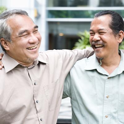 Two older male friends happy to see each other during a reunion.