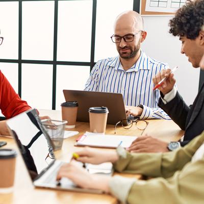 A group of coworkers happily engaged in a team meeting.