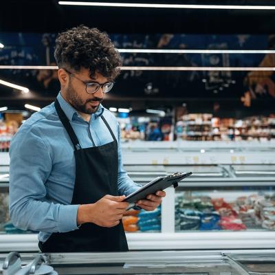 A grocery manager using a checklist for store inventory.