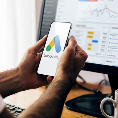 Man using a mobile phone with Google Ads on the screen.