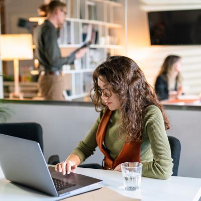 A young female entrepreneur working quietly in a modern office space.