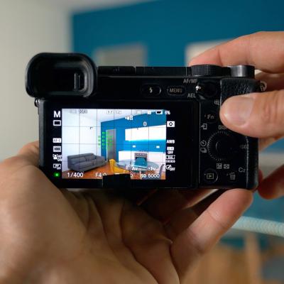 Person professionally taking a photograph of a home's interior.