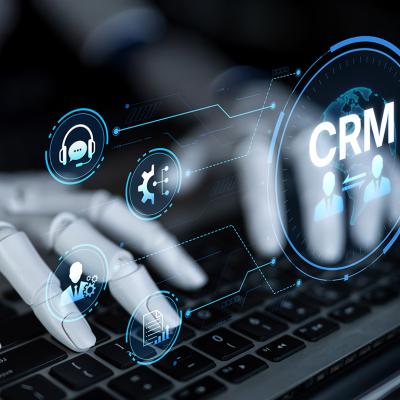 A robot enhancing CRM automation analytics and tools with artificial intelligence from a laptop.