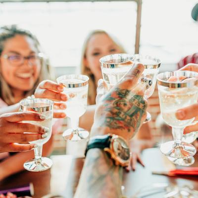 A group of friends toasting their drinks together during a celebration.