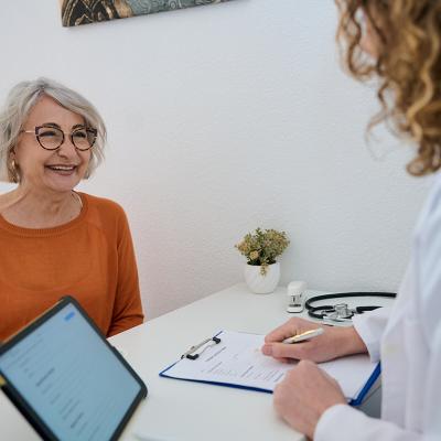 A happy senior woman talking to her doctor during a health appointment.