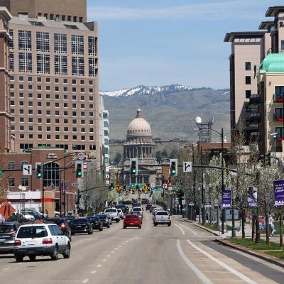 A view of the Idaho state capitol building downtown with overlooking mountains at the back.