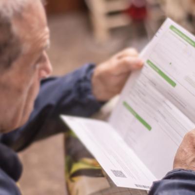 An elderly man reviewing his electricity bill.