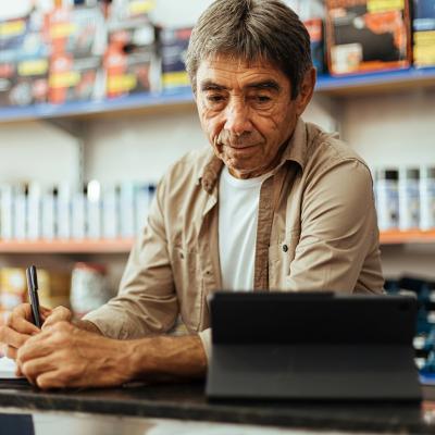 A business owner taking orders at his hardware shop.