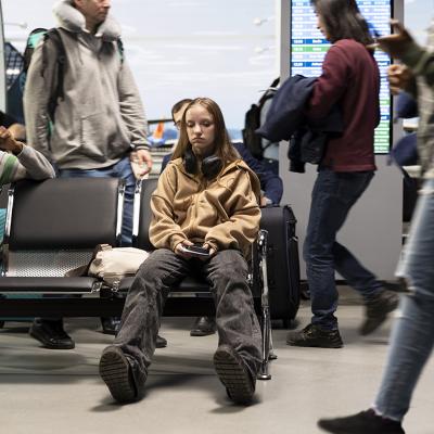 An upset young woman at the airport after a delayed flight.