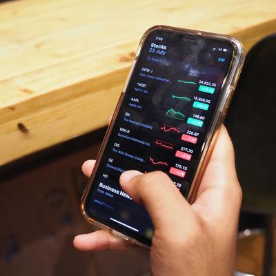 A person checking the stock market from an iPhone.