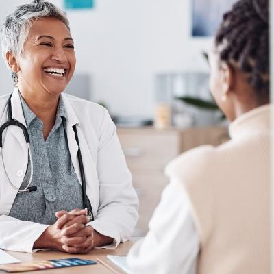 A female doctor happily engaged in a discussion with a patient.