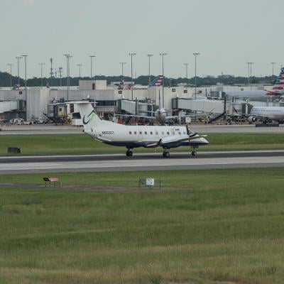 Airplanes are landing and taking off at the runway at the Charlotte Douglas International Airport with the city of Charlotte, North Carolina.