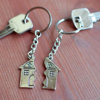 Two keys with split house pendants laid in a wooden background.