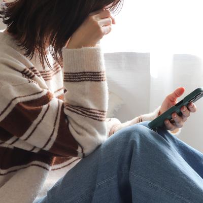 A person putting her head down while checking her smartphone.