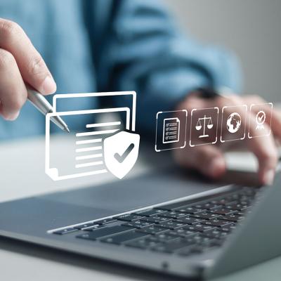 Businessman using a laptop illustrated with compliance software graphics.
