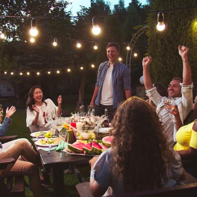 A diverse group of friends having a party at a backyard at night.