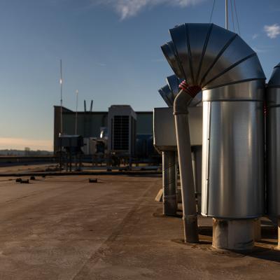 External air conditioning units and ventilation system installed on an industrial building's roof.