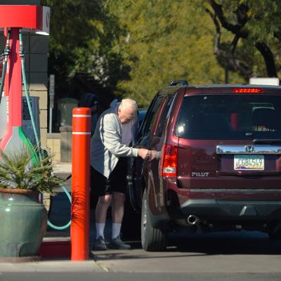 A senior citizen pumping gas into his car at a Safeway filling station in Chandler, Arizona, USA.