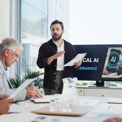An IT developer presenting AI governance topic during an office meeting.