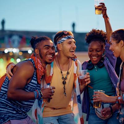 Friends enjoying and vibing to outdoors music during a summer music festival.