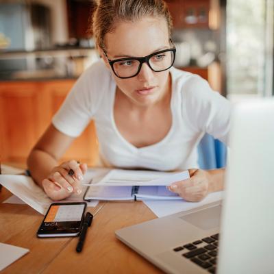 A young adult reviewing her property's documents from her laptop at home.