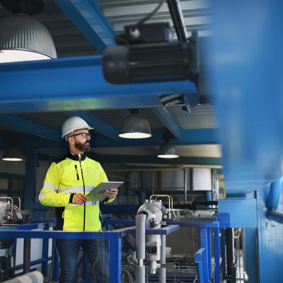 An engineer checking pipes inside an industrial factory.