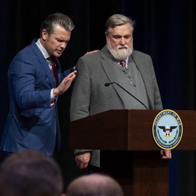 Pete Hegseth and Douglas Wilson stand at a podium during a Pentagon prayer service in February 2026.