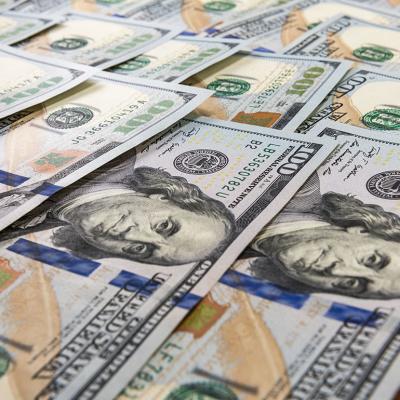 U.S. hundred dollar bills laid flat as a background. 