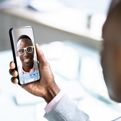 A person checking on virtual eyeglasses from an optical shop's (augmented reality) AR application online.