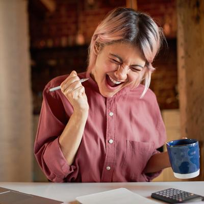 A young adult appearing to be overjoyed after finally paying off debts. 