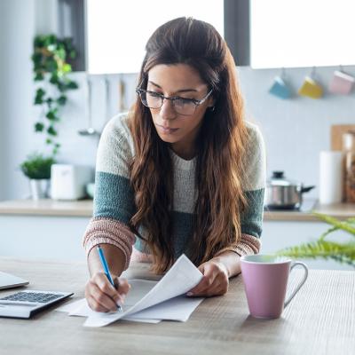 A woman reviewing finance documents at home.