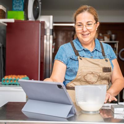 A pastry small business owner happily checking daily sales.