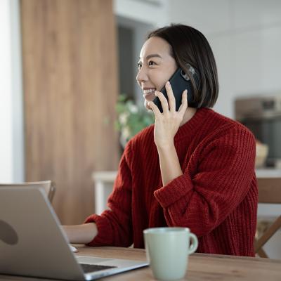 A young businesswoman on the phone while working from home.