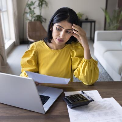 A young adult looking stressed during a personal finance review at home.