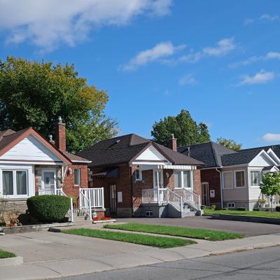 A row of detached bungalow-style brick homes in a street.