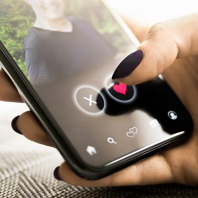 A person checking a profile of another person from a dating application in her smartphone.