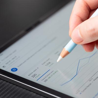 Person navigating Google Ads analytics dashboard on a tablet.