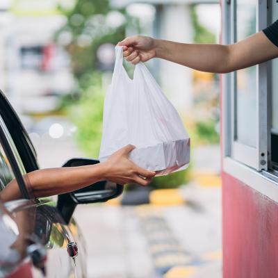 Person receiving their takeaway order at the drive thru.