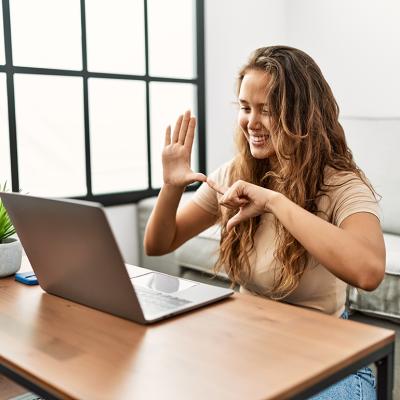 A person communicating through sign language during a Zoom video call.