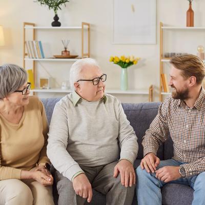 Senior parents and their adult son having a discussion at home.
