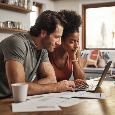 A couple planning finances together in their home kitchen.