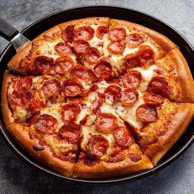 A pepperoni pizza from Pizza Hut in a deep dish ban.